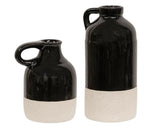 Add modern style to a coffee table with these vases. The jugs have narrow openings, small handles at the top, and are finished with a shiny black glaze with a beige, textured dipped stripe at the bottom. These jugs display beautifully alone or grouped together, empty or filled with floral and greenery stems, year-round or seasonally.   Your purchase includes one of each size vase.