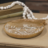 This shallow, decorative plate is made of dark wood with a natural-grain finish. The plate has a smooth, carved texture and features an embossed wildflower design inlaid with white paint. Display this plate using a plate holder or use as a base for assorted tabletop decor, fillers, or candles. This is also a great affordable gift choice.<br>