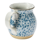This beautiful pitcher features a hand-painted blue and white floral design accented by a light brown base. It is made of food-safe stoneware and a great size for creamer or salad dressing.   Materials: Stoneware  Dimensions: 4 3/4" wide x 6 1/4" high