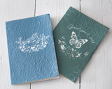 Our enchanting journals captivate a sense of artistry with their unbleached note paper and detailed paper mâché cover. Each book was fashioned with the idea that it can be a keepsake for the future, for generations to come. This is also a lovely gift for a recent high school graduate.<br><br>Your purchase includes two journals, one of each color -- blue and forest green.
