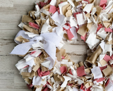 Each wreath is made using more than 3 yards of raw-cut 100% white cotton fabric strips that are between 6" and 10" long. The fabric strips are then tied onto a four-tier wire wreath form, which range in size from 16" in diameter to 20" in diameter depending on your preference. The wreath is topped with a simple handmade bow. <br>