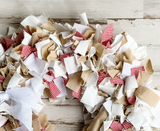 Each wreath is made using more than 3 yards of raw-cut 100% white cotton fabric strips that are between 6" and 10" long. The fabric strips are then tied onto a four-tier wire wreath form, which range in size from 16" in diameter to 20" in diameter depending on your preference. The wreath is topped with a simple handmade bow. <br>