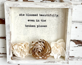 Floral wood shadowbox
Add charm and inspiration to your shop’s shelves with this handcrafted floral wood shadowbox, a perfect accent for any home decor collection. Each shadowbox is lovingly handmade with high-quality wood and features a hand-painted background with a warm, rustic finish. The heartfelt statement, "She bloomed beautifully even in the broken places" completes the look.
Materials:
Wood, wood flowers, vinyl, glitter, hanging hardware
Dimensions: 
5" wide x 5" high