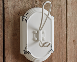 White wall hook with decorative elements on a wooden background