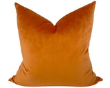 Orange velvet pillow on a white background