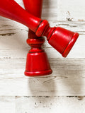 Add country charm to your dining room table with this candle holder set that complements almost any style, including rustic farmhouse and classic country. These two wood candlesticks are painted in a rich red finish and accented by a hand-rubbed black antiquing glaze. Both are finished with a clear matte wax sealer for durability. These candlesticks, which are made of a heavier wood than what is usually available at your local craft stores, each hold a standard size taper candle. <br>