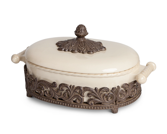 Decorative ceramic dish with ornate metal base and lid on a white background