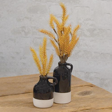 Add modern style to a coffee table with these vases. The jugs have narrow openings, small handles at the top, and are finished with a shiny black glaze with a beige, textured dipped stripe at the bottom. These jugs display beautifully alone or grouped together, empty or filled with floral and greenery stems, year-round or seasonally.&nbsp;  Your purchase includes one of each size vase.