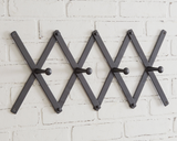 Classic black accordion wall hanging coat rack

Simple and adjustable, this black accordion coat rack has four hooks for hanging coats, scarves, and bags. To hang this up, it has a small hole on the top and bottom of each edge for a nail or screw.

Materials:
Wood, metal

Dimensions:
3" high x 37" wide&nbsp;
