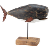 Decorative whale sculpture on a wooden base with a white background