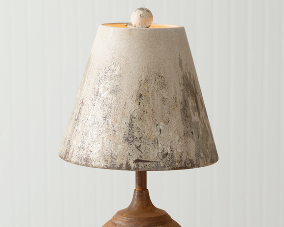 This antiqued lamp features an iron cannon ball base and a metal lampshade that has distressed colors. It takes a standard light bulb which is not included. 60-watts is the maximum suggested bulb wattage for this item. The cannon ball measures 6'' dia.