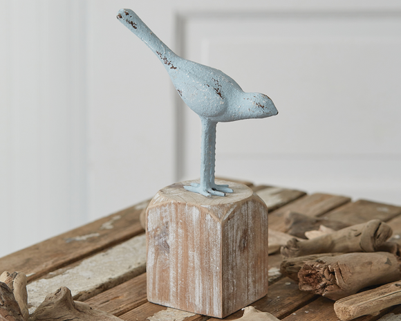 Cast iron distressed blue bird figurine on wood