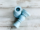 Light blue candle holders on a wooden surface