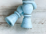 Light blue wooden candle holder on a light wooden surface