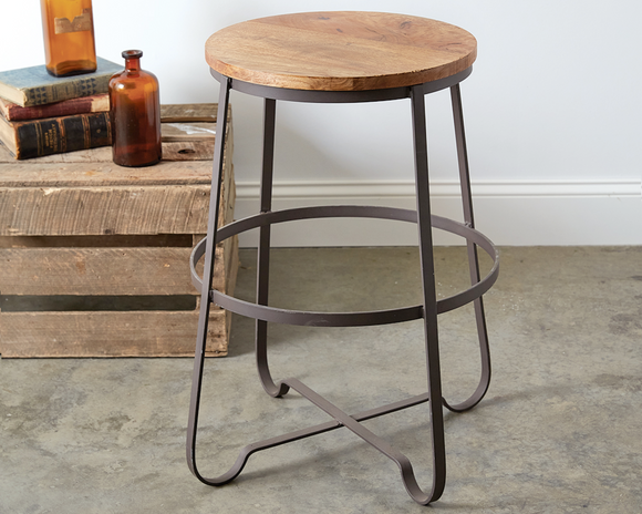 Bring a touch of industrial into your home with our small wood finished stool. The legs are made of rustic metal and finished with a wooden seat. These stools are counter height and would look great at a kitchen island.<br>