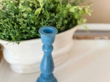 Pair of hand-painted navy blue wooden taper candlestick holders with classical turned details shown on a neutral background.
