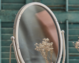 Add vintage flair to a vanity or bathroom counter with this adorable mirror. It features an aged white distressed finish accented by a curved base and easel back. This mirror is also the perfect size for a dorm room and would make for a great graduation gift.

Materials:
Glass, metal

Dimensions:
10 1/4" wide x 5 1/2" deep x 15" high