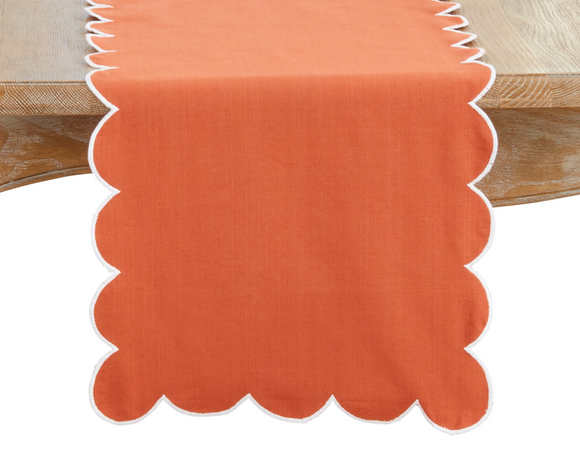 Orange table runner with scalloped edge on a wooden surface