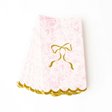 Pink lace fabric with a gold bow on a white background