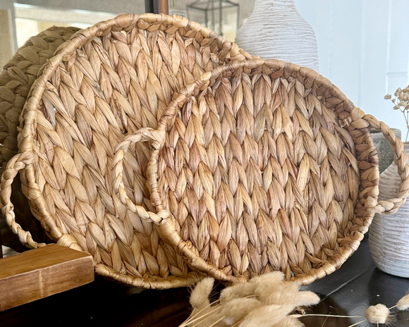 Woven basket with handles on a surface with decorative elements
