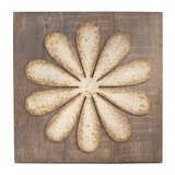 Decorative metal wall art with a floral design on a wooden background
