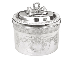 Add classic style to a bathroom counter or bedroom dresser with this gorgeous trinket box. Finished in silver, it features an etched floral design along the sides and a ribbon-shaped handle on top. This piece really is fabulous.  Materials: Metal  Dimensions: 6" round x 5 1/5" high