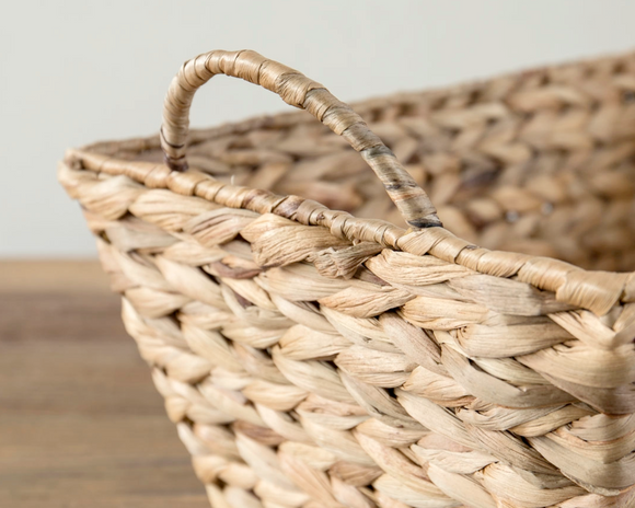 Woven basket with a handle on a wooden surface