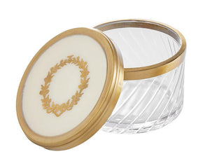 Store small bath essentials or jewelry in this gorgeous lidded jar. It features a gold-color wreath along the top of the lid with a matching rim. The glass is cut to give it a multidimensional feel. This really is a pretty piece!  Materials: Glass, brass  Dimensions: 2 1/2" high x 3 1/2" round