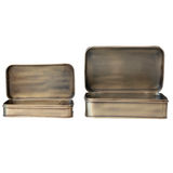 Two brass-colored metal boxes with lids on a white background