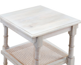 White wooden side table with a caned shelf on a white background