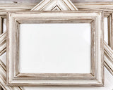 A distressed white wooden picture frame with a rustic, weathered finish, shown in a stacked arrangement with other frames behind it.