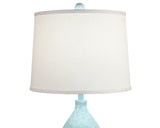 Table lamp with a white shade and light blue base on a white background