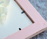 back of pink ornate picture frame