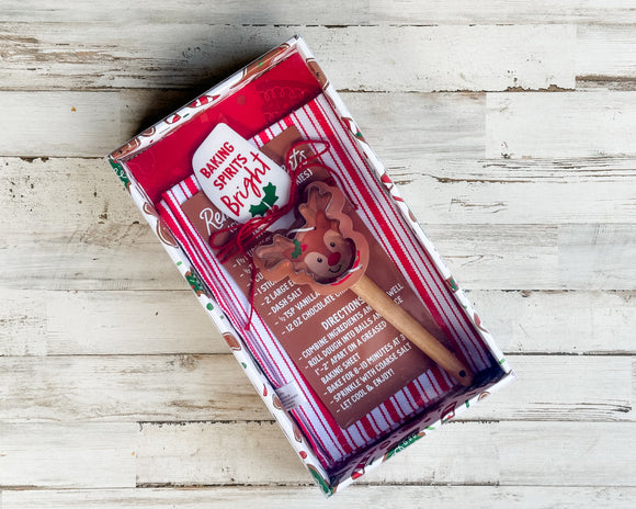 Set of Christmas-themed cookie cutters and baking set on a wooden surface
