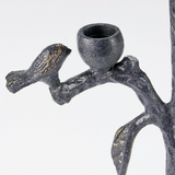 Decorative metal candle holder with bird and branch design on a white background
