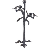 Decorative black metal candle holder shaped like a tree with birds on a white background