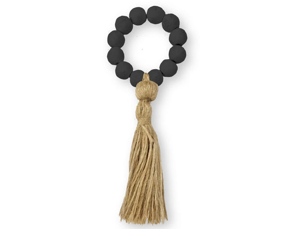 Black beaded ring with a tassel on a white background