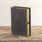 Organized remote controls and coasters on a coffee table in style with this beautiful decorative book box. It features an antique black distressed finish, a metal hook closure, and faux book pages. This item is a great gift for someone who likes to be organized.

Materials:
Wood, metal, heavy-stock paper

Dimensions:
9" wide x 3" deep x 12" long