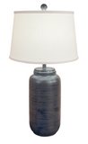 Table lamp with a textured black base and white shade on a white background