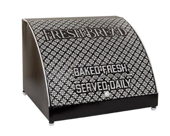 This bread box features a painted antique black finish with white quatrefoils atop a classic metal bread box. It reads, “Fresh Bread,” “Baked Fresh,” and, “Served Daily.” It comes with a functional hinged lid and is a charming way to organize in the kitchen.  Materials: Metal  Dimensions: 13 1/2