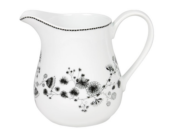 White ceramic pitcher with black floral patterns on a white background