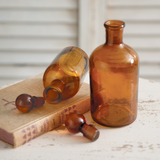 Two brown glass bottles on an old book with a neutral background