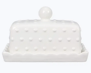 White ceramic butter dish with textured surface and pearl-like knob on a white background