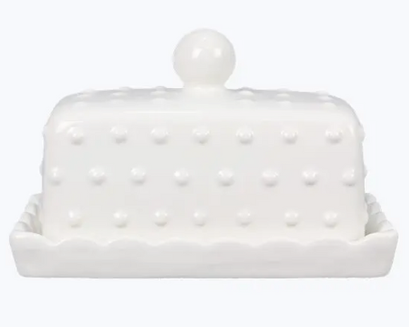 White ceramic butter dish with textured surface and pearl-like knob on a white background