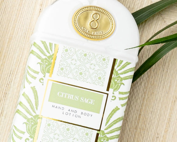 Hand and body lotion bottle with 'Citrus Sage' label on a wooden surface