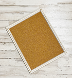 Cork bulletin board with white frame on a wooden surface, jabella designs, home decor, home office decor, pottery barn style