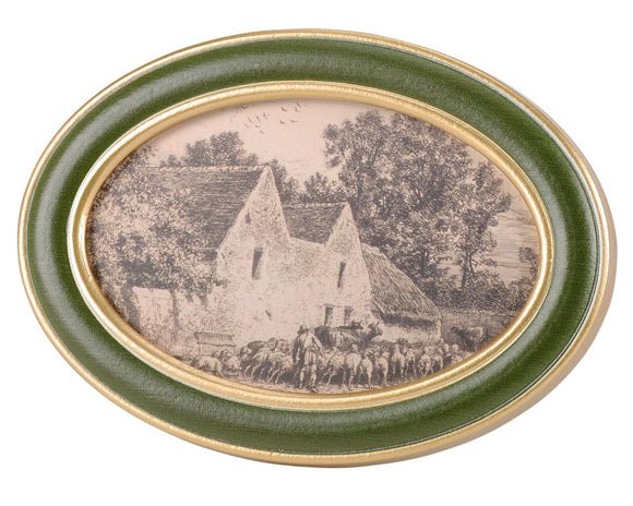 This small framed art piece displays a cottage farm in a hand illustrated sketch style. The frame features an oval shape with a green finish accented with metallic gold. It is easy to hang for display via the attached saw-tooth hanger or can free stand using the back easel. 
