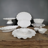 Set of white ceramic dishes on a wooden surface with a gray background