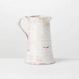 White ceramic pitcher with rustic texture on a light gray background