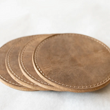 Set of brown leather coasters on a white surface
